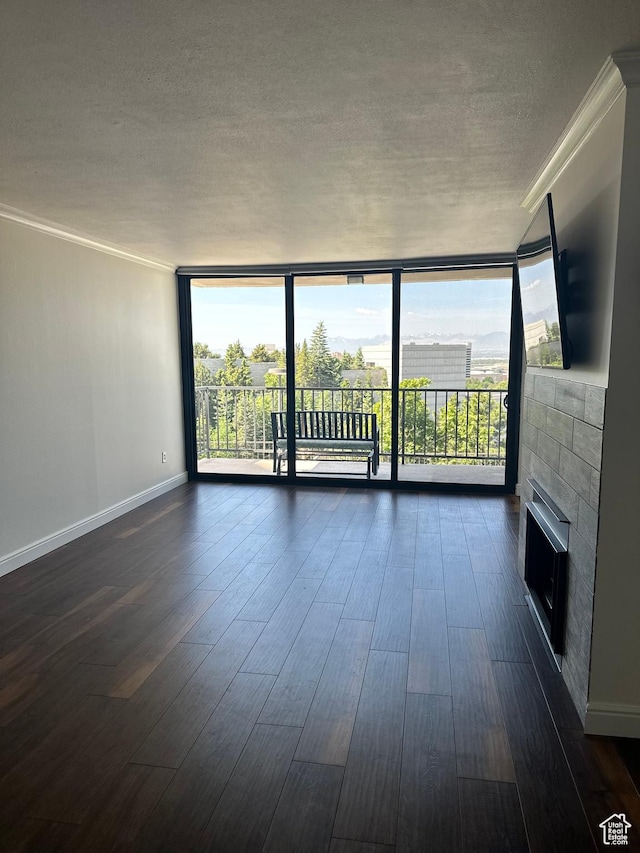 241 N Vine St E Unit 207W, Salt Lake City, UT 84103 - unfurnished living room featuring a wall of windows, a textured ceiling, healthy amount of natural light, dark wood-style floors, and a fireplace