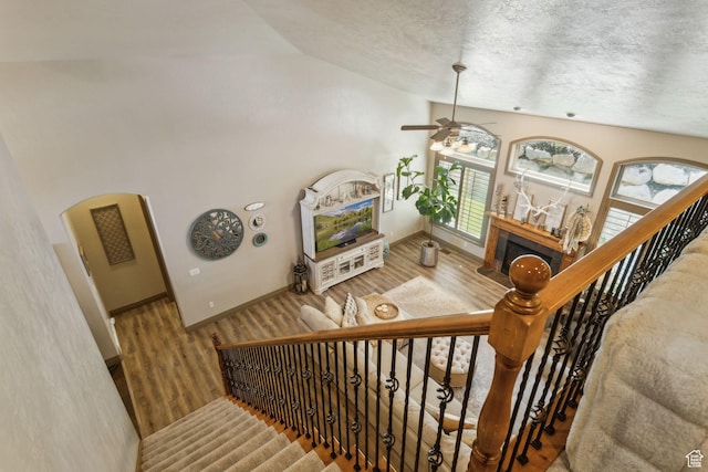 1744 E Burning Oak Dr, Draper, UT 84020 - staircase with vaulted ceiling, wood finished floors, ceiling fan, a textured ceiling, and a fireplace