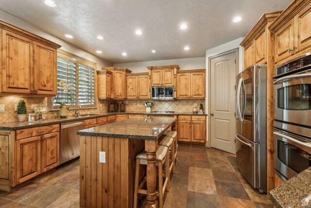 1744 E Burning Oak Dr, Draper, UT 84020 - kitchen featuring appliances with stainless steel finishes, a center island, a sink, stone tile floors, and recessed lighting