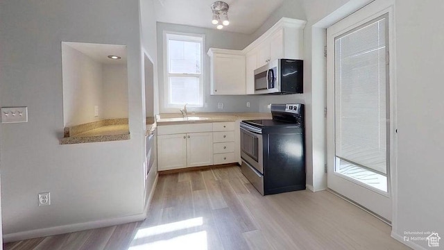 358 E 100 N, Provo, UT 84606 - kitchen with appliances with stainless steel finishes, white cabinets, light wood finished floors, a sink, and baseboards