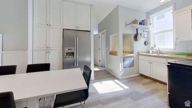 358 E 100 N, Provo, UT 84606 - kitchen with stainless steel fridge with ice dispenser, light wood-style floors, white cabinets, light countertops, and black electric range oven