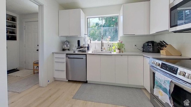 358 E 100 N, Provo, UT 84606 - kitchen with stainless steel appliances, light wood-type flooring, white cabinets, light countertops, and a sink