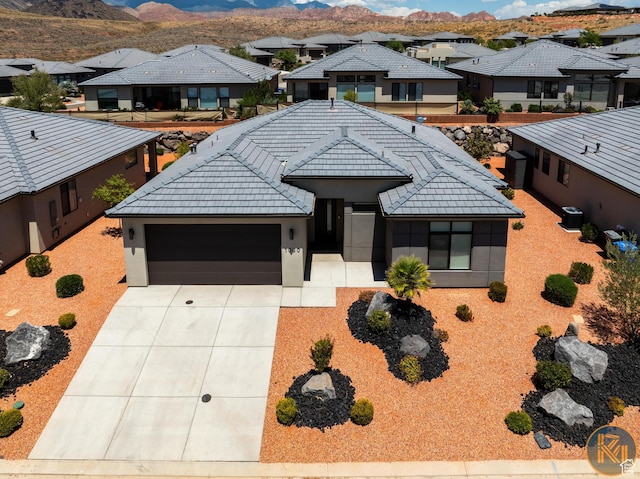 1060 W Jonathon Dr, Washington, UT 84780 - view of front of house with a residential view, a garage, driveway, stucco siding, and a mountain view