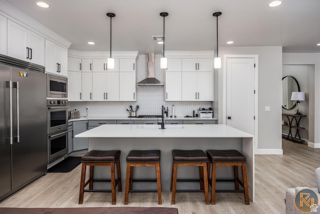 1060 W Jonathon Dr, Washington, UT 84780 - kitchen with built in appliances, a sink, wall chimney range hood, a kitchen breakfast bar, and decorative backsplash