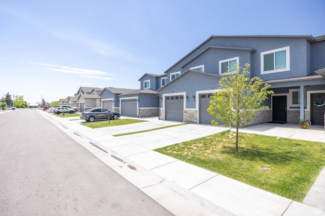 200 W 1200 S Unit 52, Tremonton, UT 84337 - view of front of house featuring driveway, stone siding, stucco siding, a residential view, and a front lawn