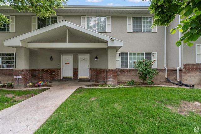 7638 S Redwood Rd Unit 17, West Jordan, UT 84084 - view of property with stucco siding, brick siding, and a front yard