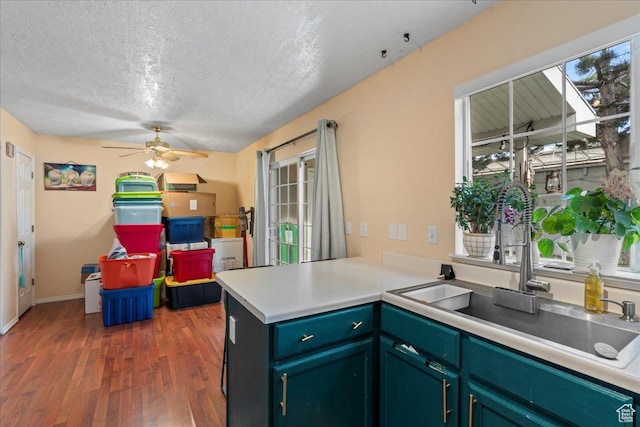 7638 S Redwood Rd Unit 17, West Jordan, UT 84084 - kitchen featuring a textured ceiling, wood finished floors, a sink, a peninsula, and a ceiling fan