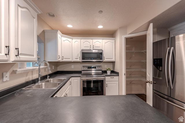 943 W 580 S Unit 97, Pleasant Grove, UT 84062 - kitchen featuring appliances with stainless steel finishes, a sink, dark countertops, white cabinets, and recessed lighting