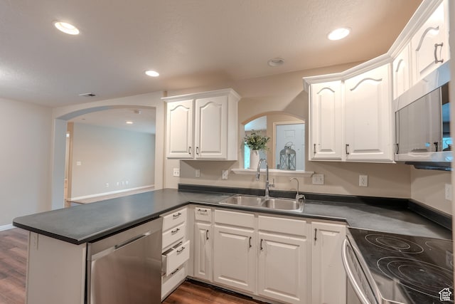 943 W 580 S Unit 97, Pleasant Grove, UT 84062 - kitchen featuring arched walkways, appliances with stainless steel finishes, a sink, dark countertops, and recessed lighting