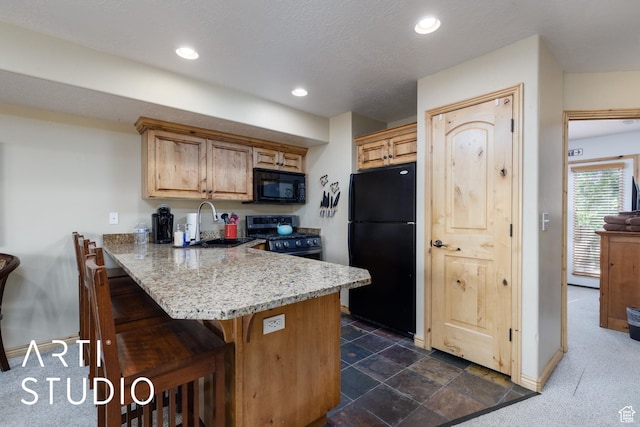 3521 N Moose Hollow Dr Unit 1202, Eden, UT 84310 - kitchen with black appliances, a sink, a breakfast bar, a peninsula, and baseboards