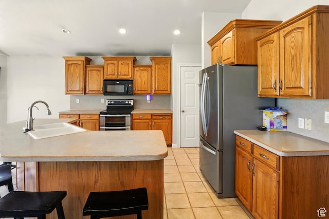 2865 W 3600 N, Farr West, UT 84404 - kitchen featuring appliances with stainless steel finishes, a sink, light tile patterned floors, brown cabinetry, and light countertops