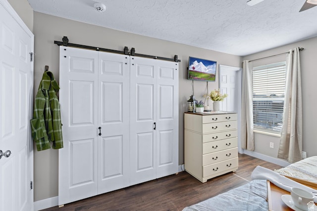 1962 W 12110 S, Riverton, UT 84065 - bedroom featuring a barn door, dark wood-style floors, a textured ceiling, and baseboards