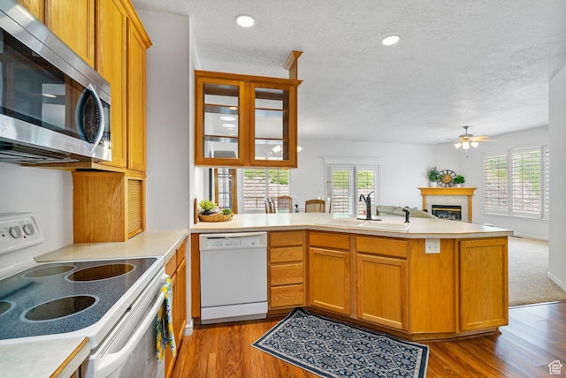 12482 S Tithing Point Dr, Riverton, UT 84065 - kitchen featuring white appliances, a sink, a peninsula, healthy amount of natural light, and a textured ceiling