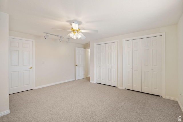 12482 S Tithing Point Dr, Riverton, UT 84065 - unfurnished bedroom with carpet, two closets, baseboards, ceiling fan, and rail lighting
