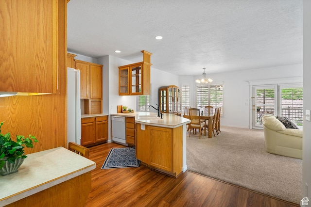 12482 S Tithing Point Dr, Riverton, UT 84065 - kitchen featuring white appliances, a peninsula, a sink, a textured ceiling, and glass insert cabinets