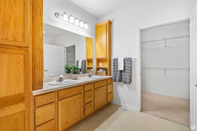 12482 S Tithing Point Dr, Riverton, UT 84065 - full bathroom with double vanity, tile patterned floors, a spacious closet, and baseboards