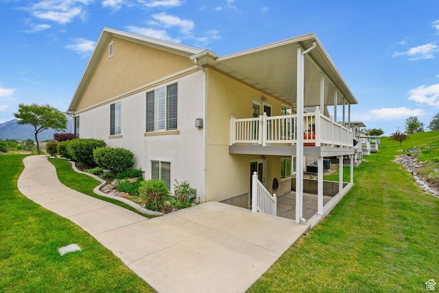 12482 S Tithing Point Dr, Riverton, UT 84065 - view of side of property with a lawn, a patio area, and stucco siding