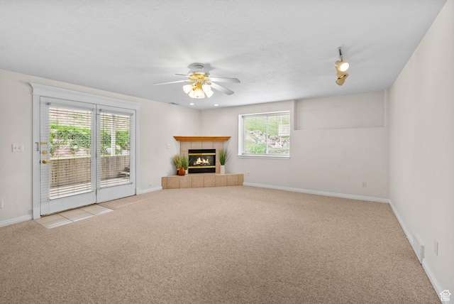 12482 S Tithing Point Dr, Riverton, UT 84065 - unfurnished living room with carpet floors, ceiling fan, healthy amount of natural light, a tile fireplace, and a textured ceiling