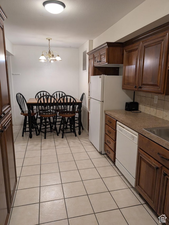240 E 400 N Unit 41, Logan, UT 84321 - kitchen with white dishwasher, a chandelier, light tile patterned flooring, hanging light fixtures, and dark countertops