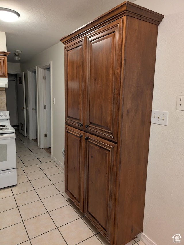 240 E 400 N Unit 41, Logan, UT 84321 - kitchen with white range with electric stovetop, light tile patterned floors, baseboards, and range hood