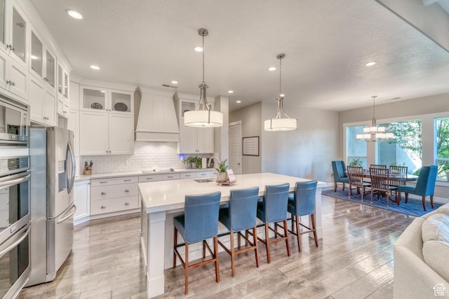 3207 W 2650 S, Hurricane, UT 84737 - kitchen featuring custom range hood, stainless steel appliances, light countertops, a sink, and tasteful backsplash