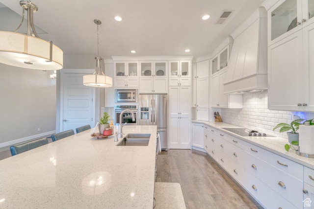 3207 W 2650 S, Hurricane, UT 84737 - kitchen featuring stainless steel appliances, custom range hood, a sink, light wood-style floors, and white cabinets