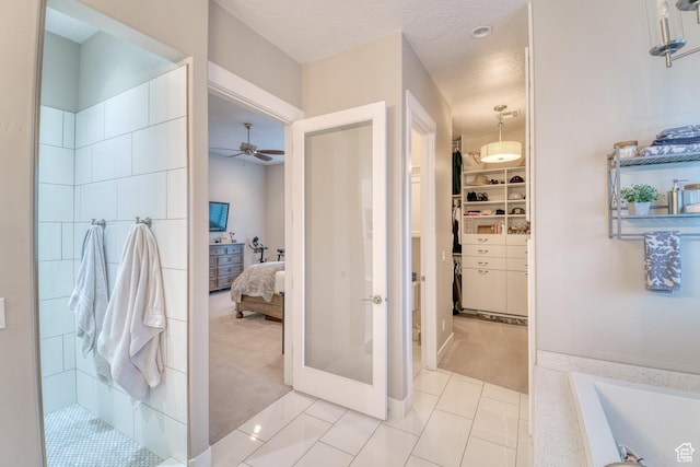 3207 W 2650 S, Hurricane, UT 84737 - ensuite bathroom with ceiling fan, a bath, a walk in closet, baseboards, and tiled shower
