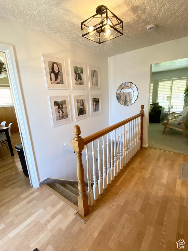 1321 Darling St, Ogden, UT 84403 - stairway with wood finished floors, a textured ceiling, a chandelier, and baseboards