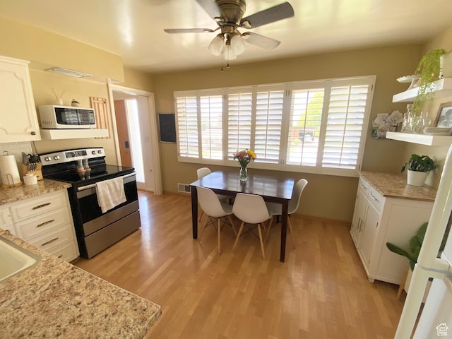 1321 Darling St, Ogden, UT 84403 - kitchen featuring stainless steel range with electric cooktop, white microwave, light wood-style flooring, white cabinetry, and a ceiling fan