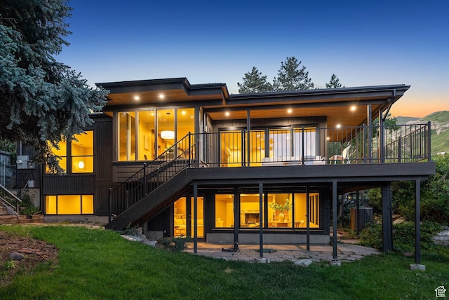2655 E Hiawatha Cir, Salt Lake City, UT 84108 - back of property at dusk with stairs, a yard, a patio, a wooden deck, and central AC unit
