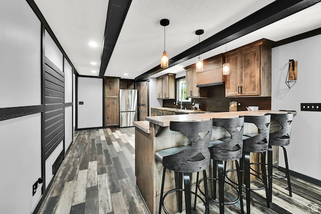 2195 W 4250 S, Roy, UT 84067 - kitchen featuring freestanding refrigerator, a peninsula, dark wood-style flooring, a breakfast bar, and light countertops