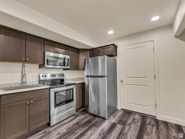 5636 W Lost Mine Ln, Herriman, UT 84096 - kitchen with appliances with stainless steel finishes, a sink, dark brown cabinets, dark wood-style floors, and recessed lighting