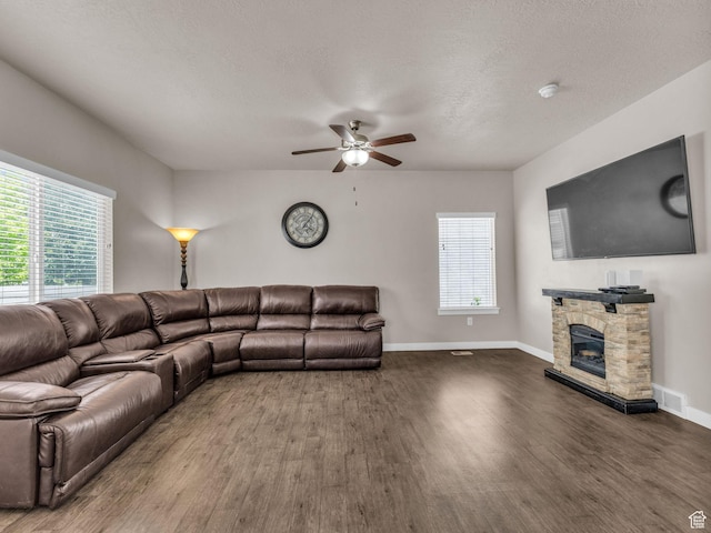 5636 W Lost Mine Ln, Herriman, UT 84096 - living room with wood finished floors, ceiling fan, a stone fireplace, and baseboards