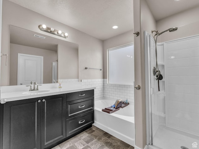 5636 W Lost Mine Ln, Herriman, UT 84096 - bathroom with a shower stall, a bath, vanity, and a textured ceiling