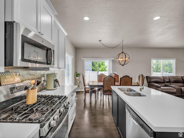 5636 W Lost Mine Ln, Herriman, UT 84096 - kitchen with appliances with stainless steel finishes, a sink, a textured ceiling, light countertops, and healthy amount of natural light
