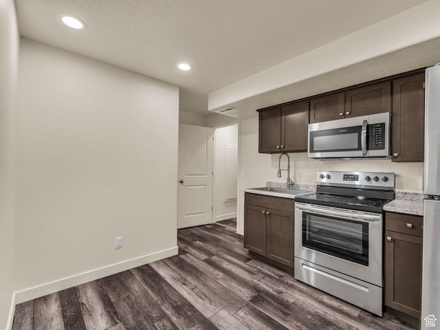 5636 W Lost Mine Ln, Herriman, UT 84096 - kitchen featuring stainless steel appliances, a sink, dark brown cabinetry, dark wood finished floors, and recessed lighting
