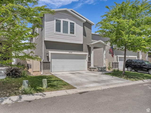 5636 W Lost Mine Ln, Herriman, UT 84096 - view of front of home featuring brick siding, concrete driveway, an attached garage, and stucco siding