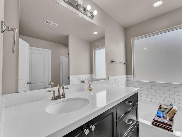 5636 W Lost Mine Ln, Herriman, UT 84096 - bathroom with vanity, a garden tub, and recessed lighting