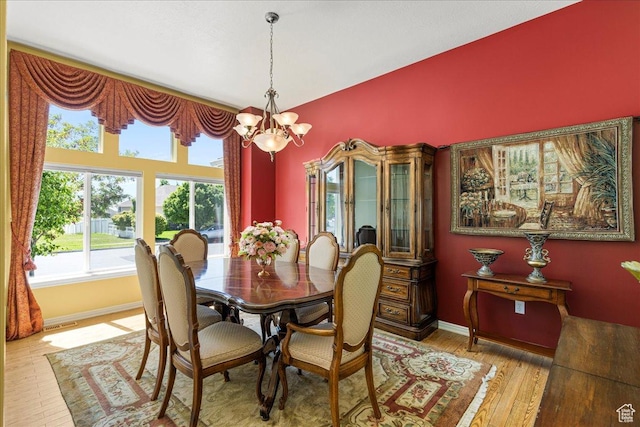 6142 N Schooner Ln, Stansbury Park, UT 84074 - dining area with plenty of natural light, a chandelier, wood finished floors, and baseboards