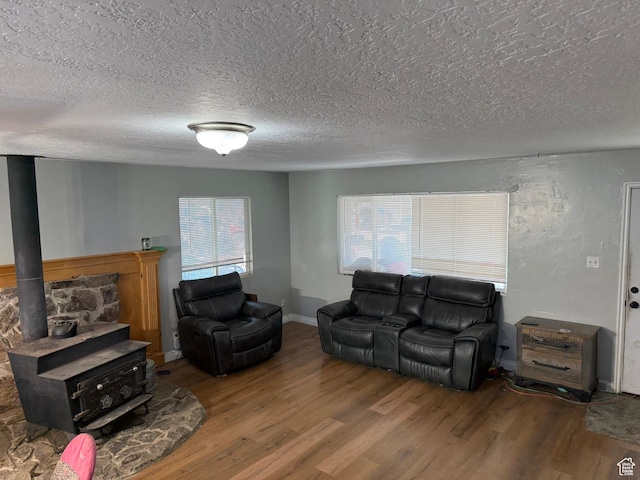 239 W Plum St, Grantsville, UT 84029 - living area featuring wood finished floors, a textured ceiling, a wood stove, and baseboards
