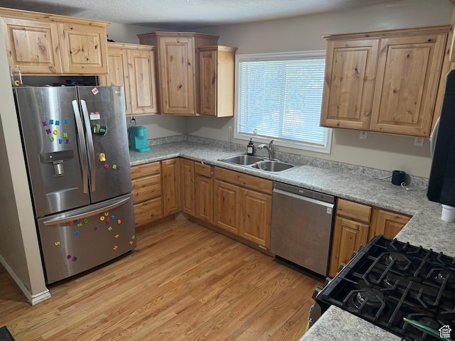 239 W Plum St, Grantsville, UT 84029 - kitchen with stainless steel appliances, a sink, light wood finished floors, light countertops, and light brown cabinets