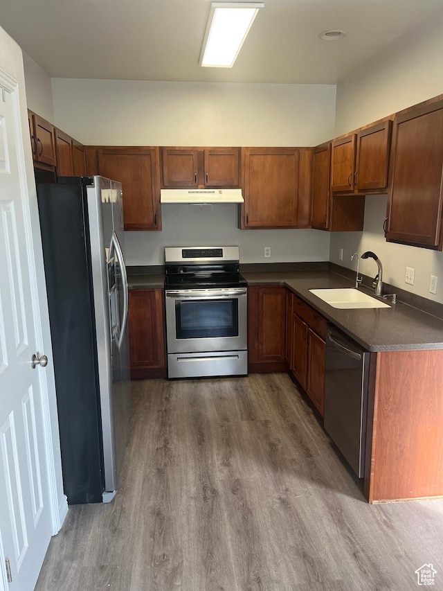 2027 W 2175 N, Lehi, UT 84043 - kitchen featuring appliances with stainless steel finishes, under cabinet range hood, dark countertops, a sink, and dark wood-style floors