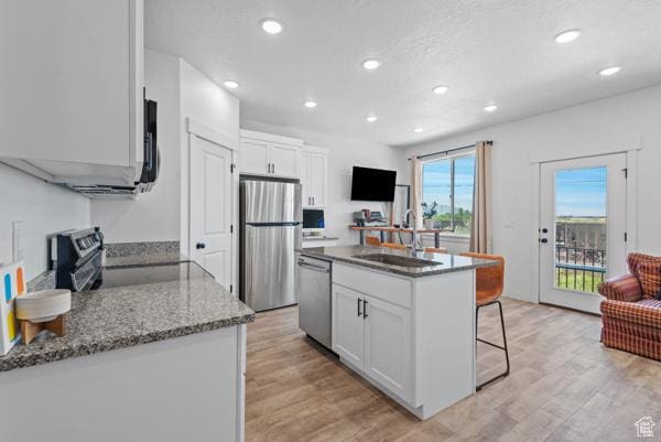 1024 E 1300 S Unit 31, Provo, UT 84606 - kitchen featuring stainless steel appliances, a sink, a breakfast bar, white cabinetry, and stone counters