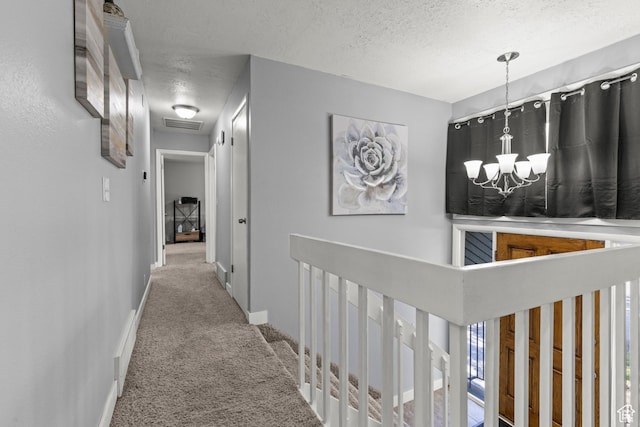 720 Freedom Cir N, Salt Lake, UT 84054 - hallway featuring carpet floors, a textured ceiling, a chandelier, an upstairs landing, and baseboards