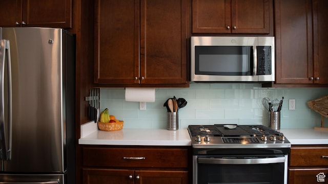 5308 W Solafax Ln S, Herriman, UT 84096 - kitchen with stainless steel appliances, light countertops, tasteful backsplash, and dark brown cabinetry
