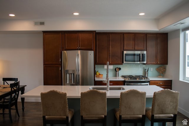 5308 W Solafax Ln S, Herriman, UT 84096 - kitchen with stainless steel appliances, light countertops, decorative backsplash, dark wood-style floors, and a kitchen island with sink