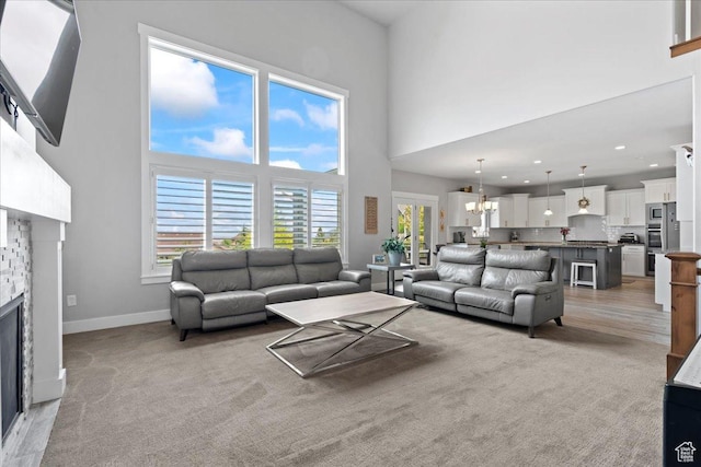 6688 W Buck Dr, Herriman, UT 84096 - living room featuring a towering ceiling, a fireplace, a chandelier, baseboards, and recessed lighting