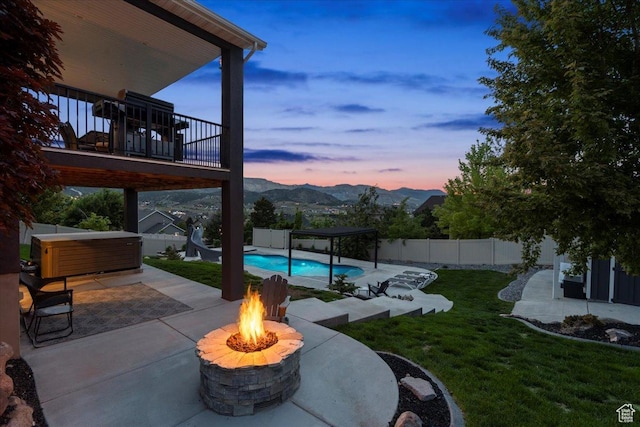 6688 W Buck Dr, Herriman, UT 84096 - patio terrace at dusk with a jacuzzi, a fire pit, a patio area, and a pergola