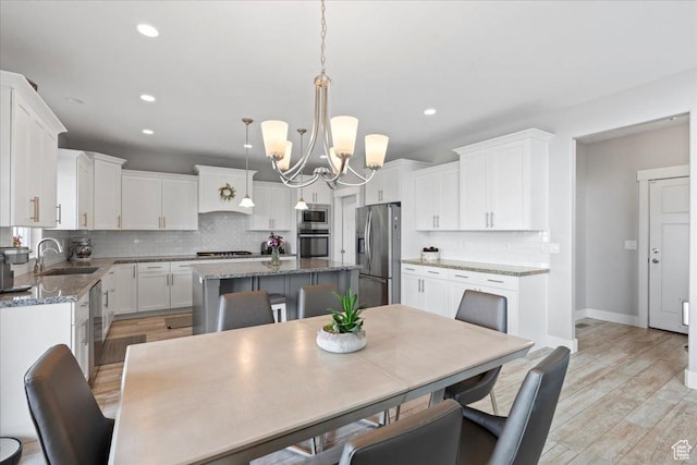 6688 W Buck Dr, Herriman, UT 84096 - dining area with a chandelier, recessed lighting, light wood finished floors, and baseboards