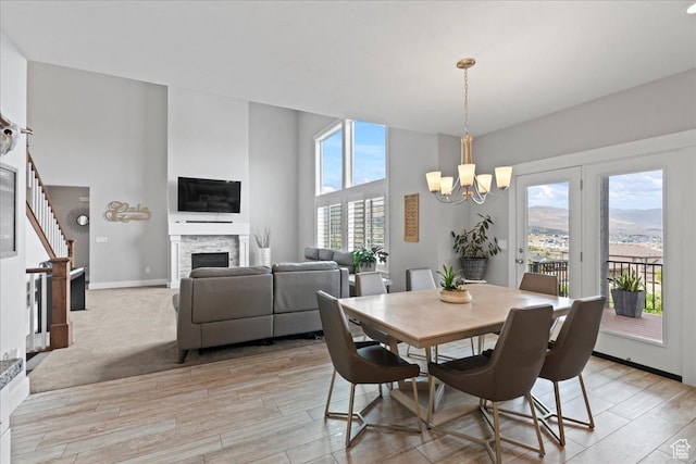 6688 W Buck Dr, Herriman, UT 84096 - dining room with a chandelier, a fireplace, light wood-type flooring, and baseboards